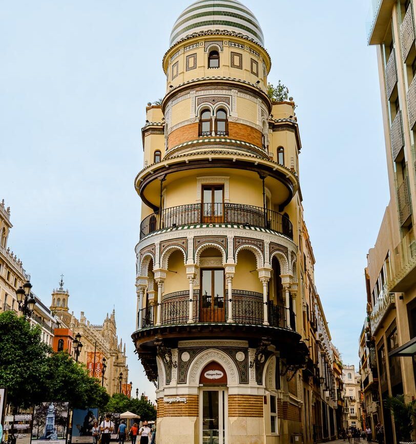 abgerundetes gebaeude mit andalusischer fassade an der strassenecke