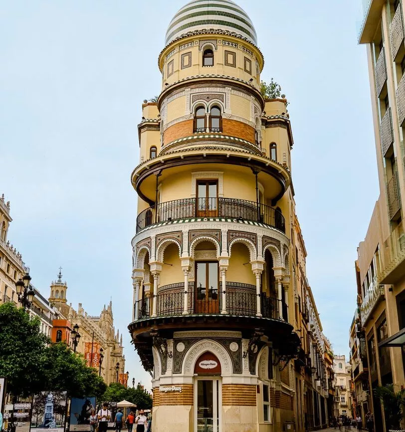 abgerundetes gebaeude mit andalusischer fassade an der strassenecke
