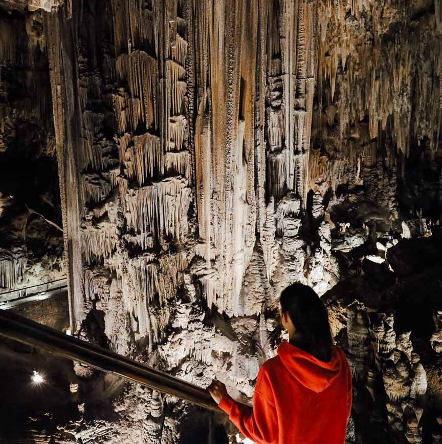 besucher beobachtet stalaktitenformationen in andalusischer hoehle