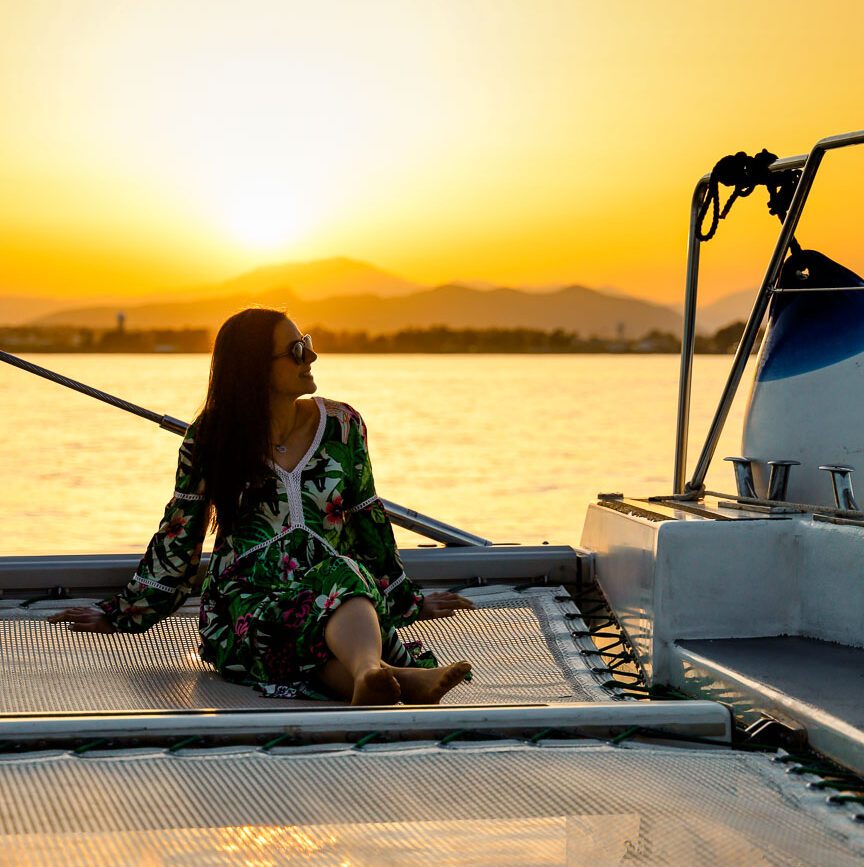 frau im blumenkleid auf boot in andalusien bei sonnenuntergang