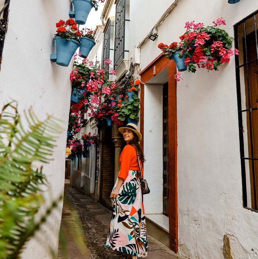 frau im kleid steht in enger andalusien gasse