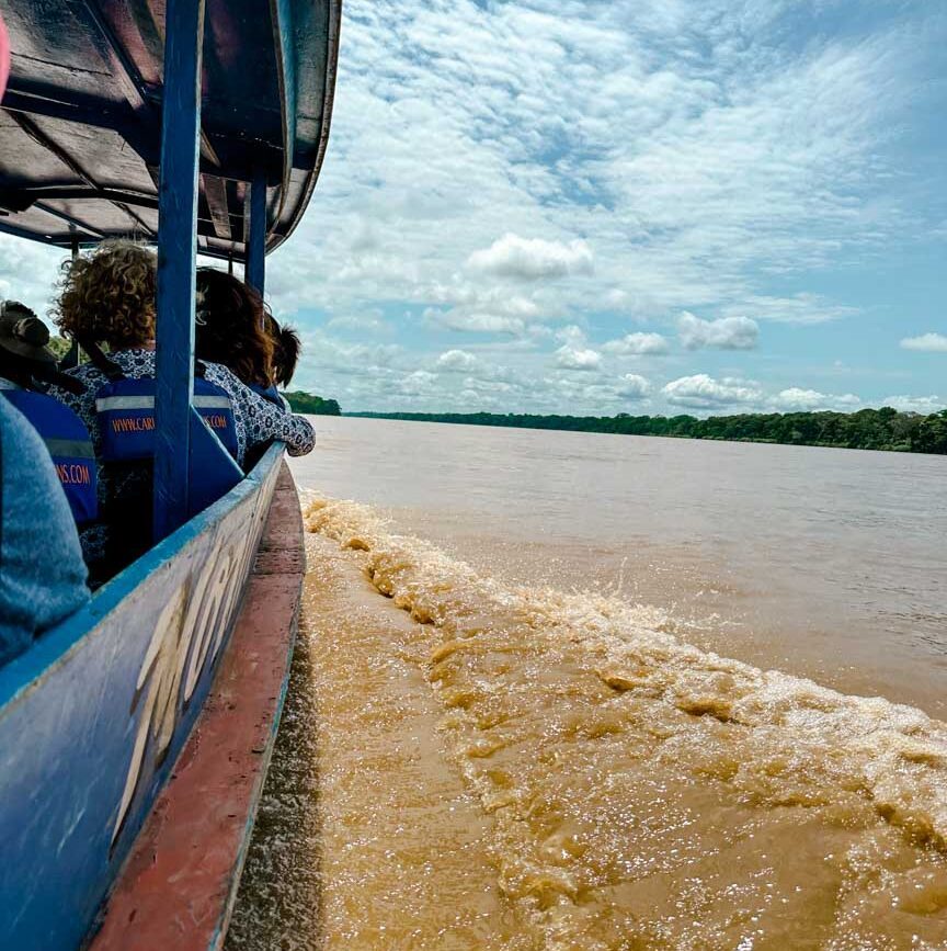 gruppe faehrt mit boot auf amazonas durch den dschungel