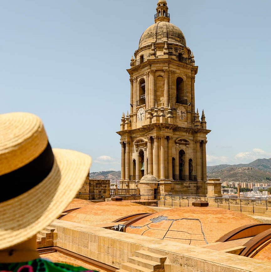 person betrachtet andalusischen turm und daecher bei der kathedrale in malaga