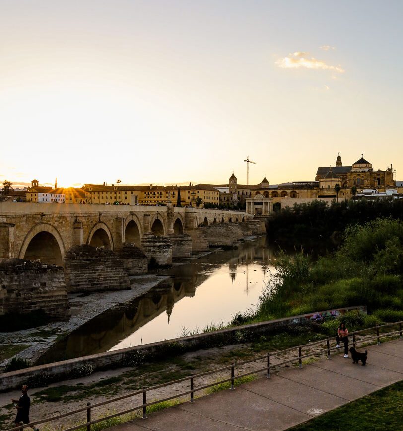 sonnenuntergang ueber der historischen bruecke in andalusien