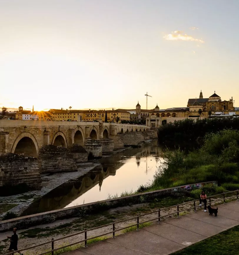 sonnenuntergang ueber der historischen bruecke in andalusien