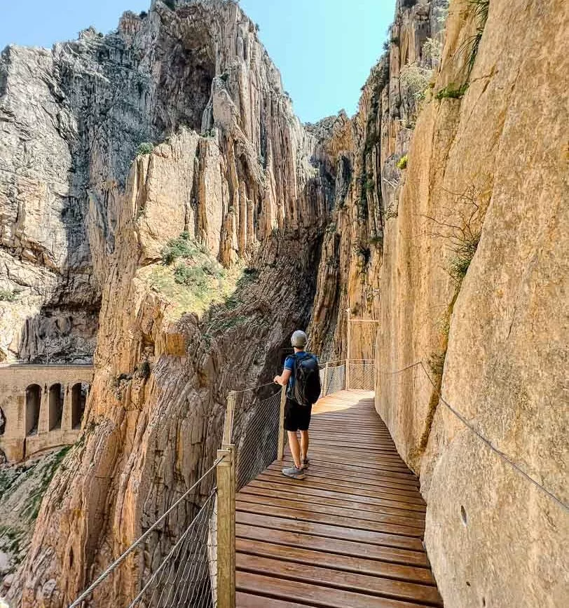tom auf schmalem holzsteg an andalusischer steilkueste