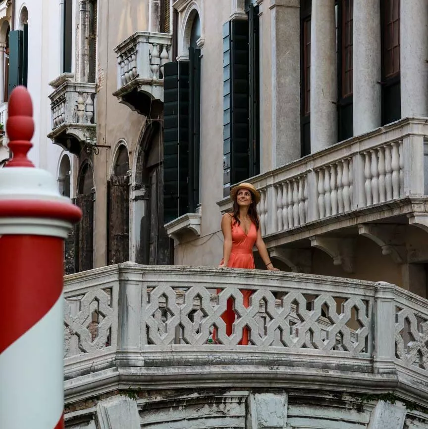 Frau in rotem Kleid auf Brücke in Venedig