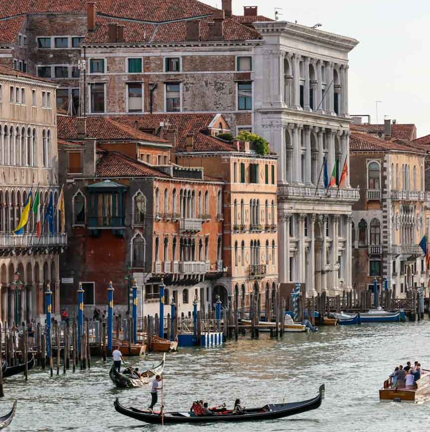 Gondel mit Passagieren in belebten Venedig-Kanal