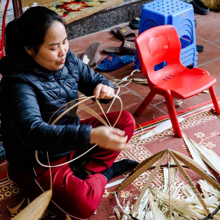 eine frau in hanoi bastelt kegelhut
