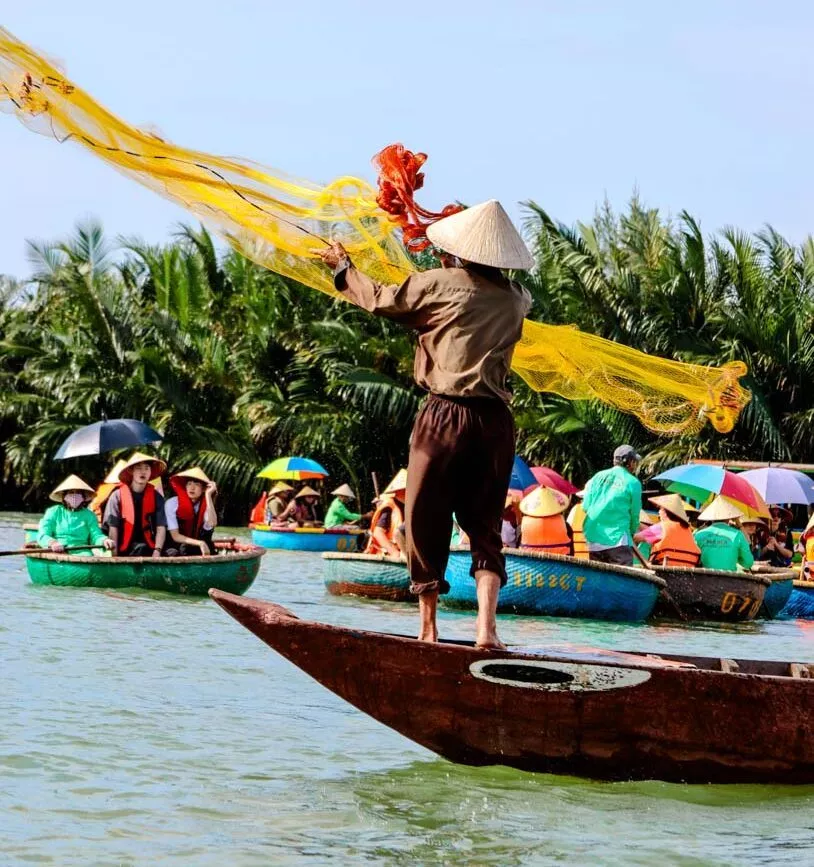 eine person wirft in hoi an ein fischernetz von einem boot aus aus