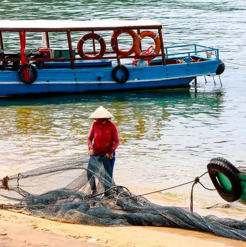 Fischer legt Netze zusammen am Strand in Vietnam