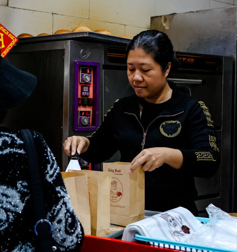 frau packt in baeckerei artikel in king roti tuete
