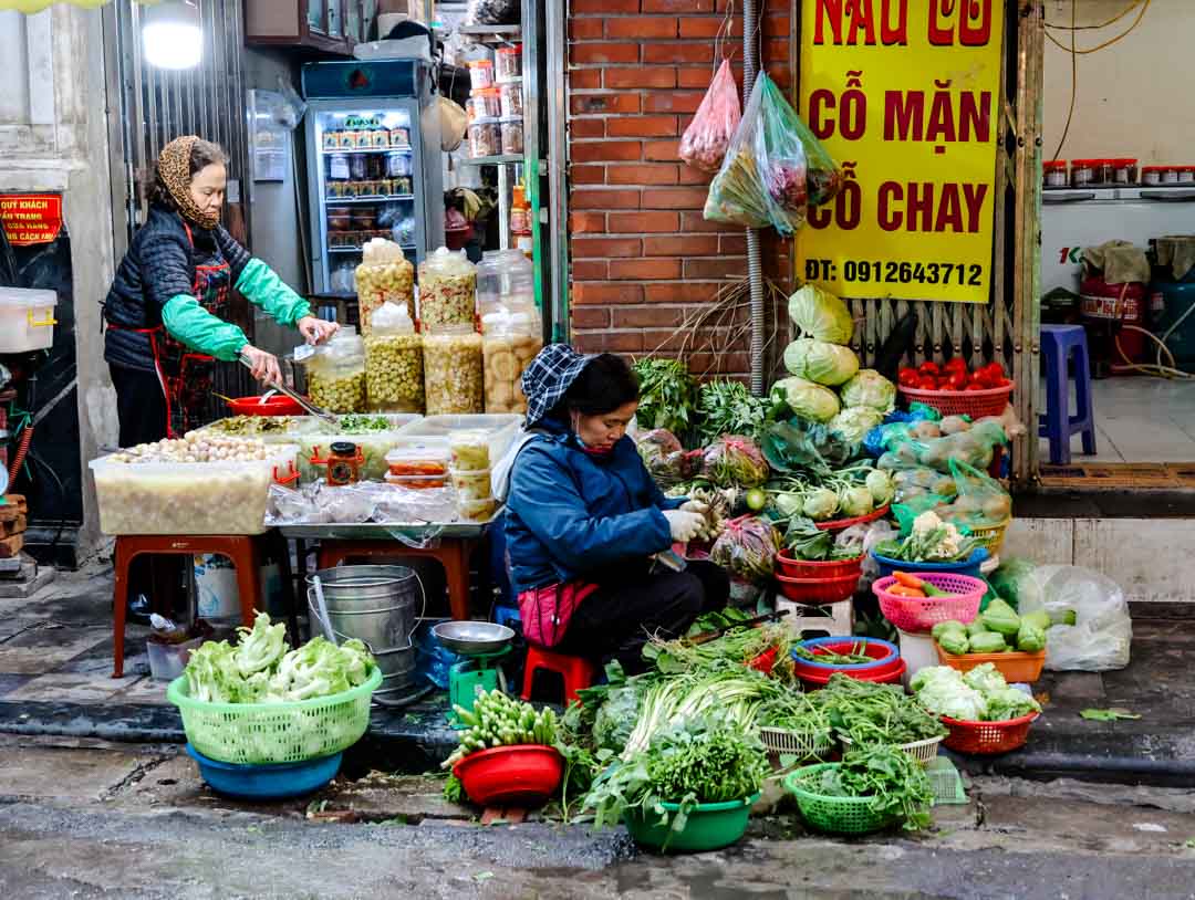 Händler auf einem Markt in Hanoi bereiten Essen zu