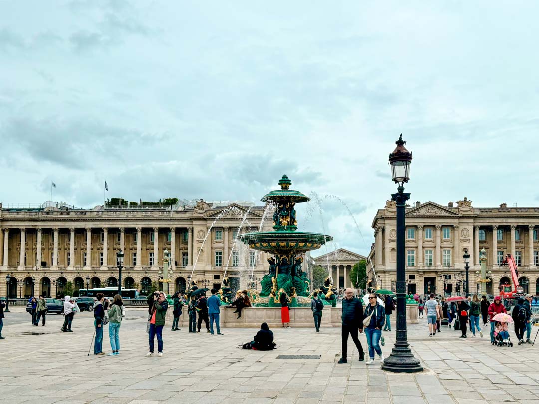 menschen versammeln sich um einen brunnen in paris place de la concorde