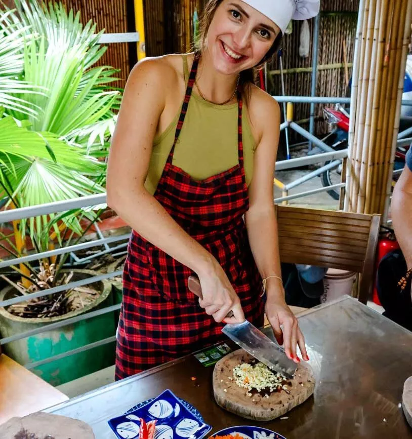 nina schneidet gemuese in einer kueche in hoi an