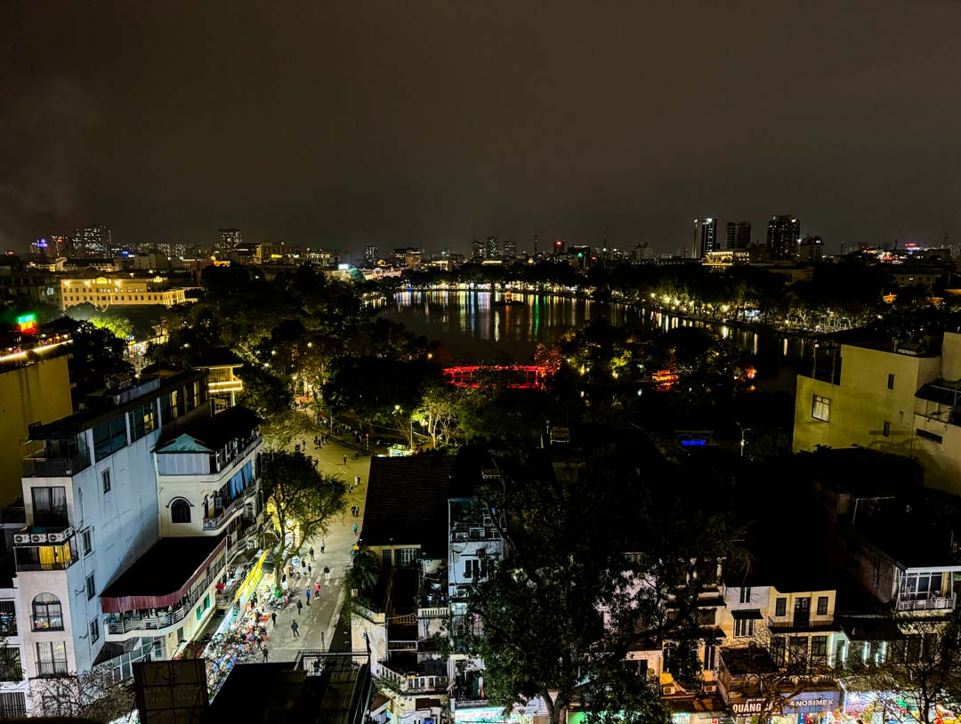 stadtbild von hanoi beleuchtete gebaeude belebte strassen ruhiger see dunkler himmel