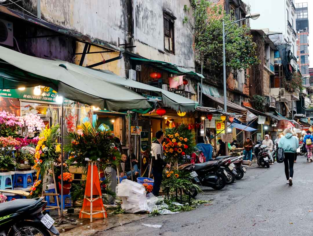 strassenmarkt in hanoi blumenstaende motorraeder