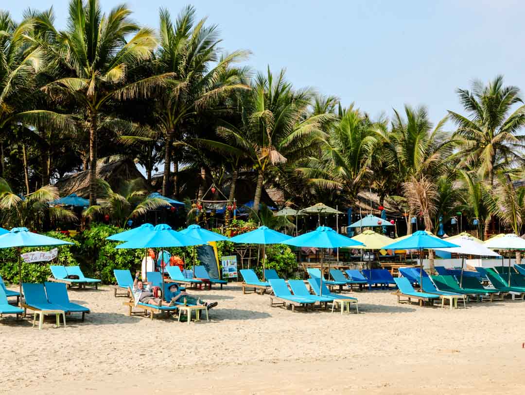 stuehle und sonnenschirme an einem strand in hoi an vietnam