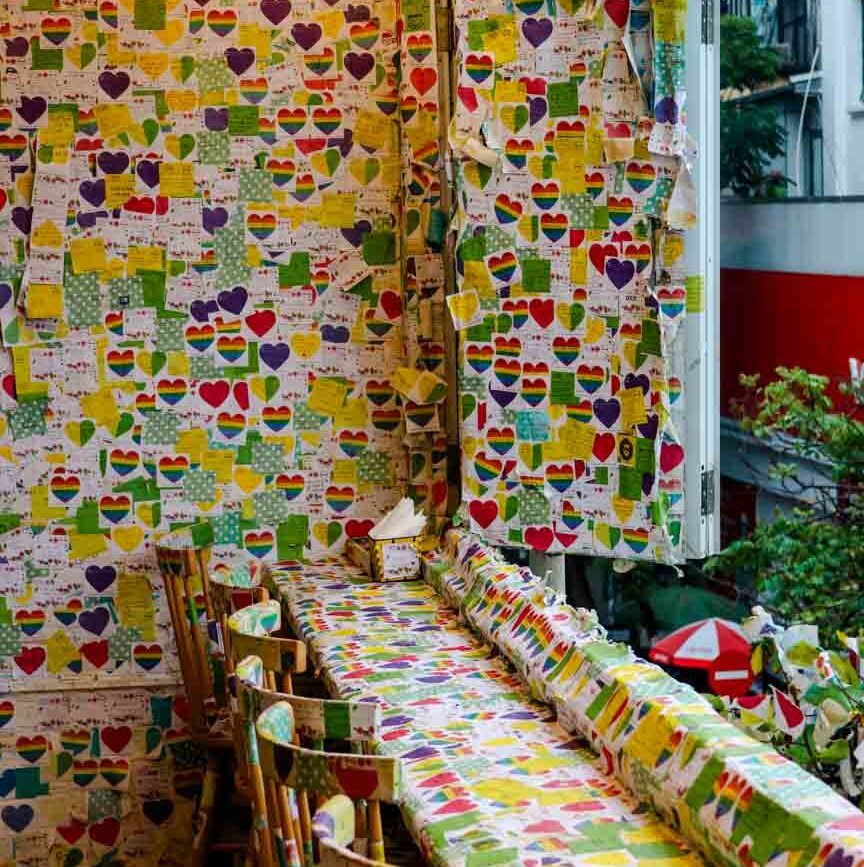 zimmer mit tapezierten waenden tisch stuehlen fenster mit blick auf strassenszene in hanoi