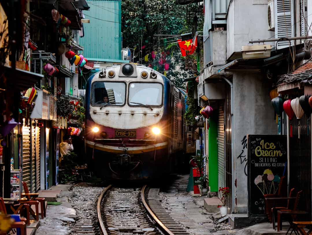 zug faehrt durch train street in hanoi