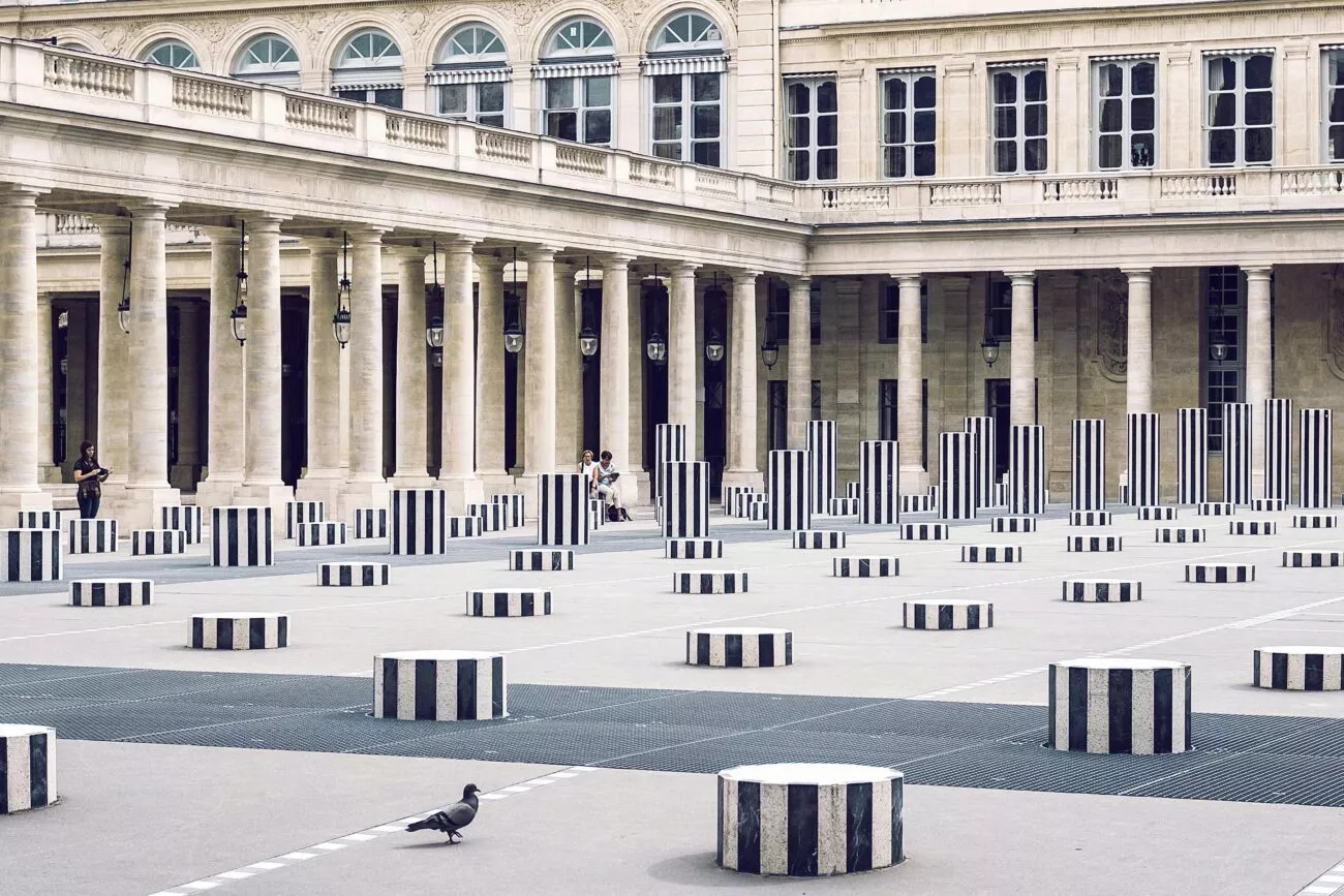 innenhof in paris mit gestreiften saeulen und taube