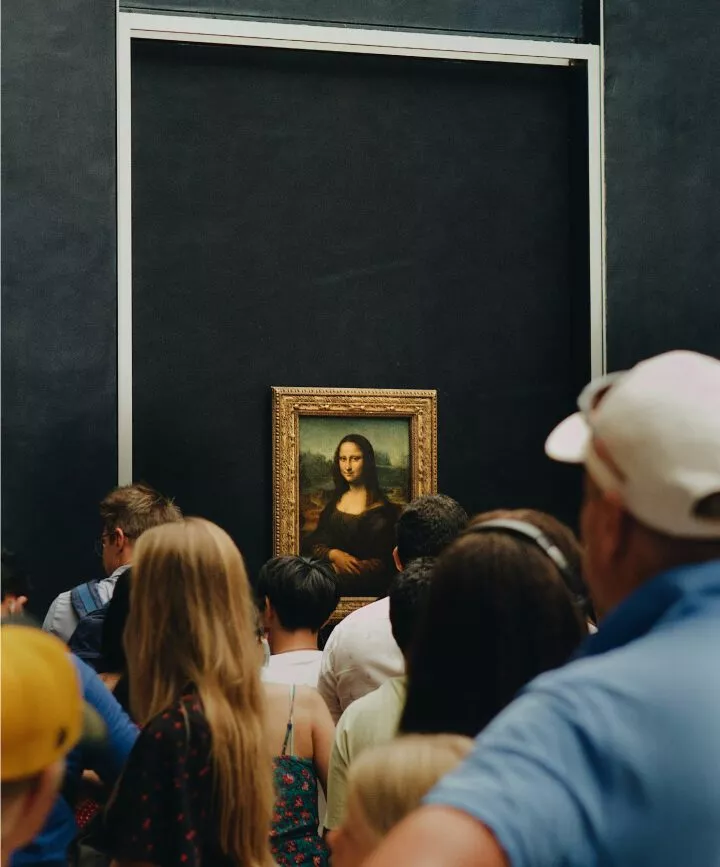 menschenmenge betrachtet mona lisa im dunklen louvre raum