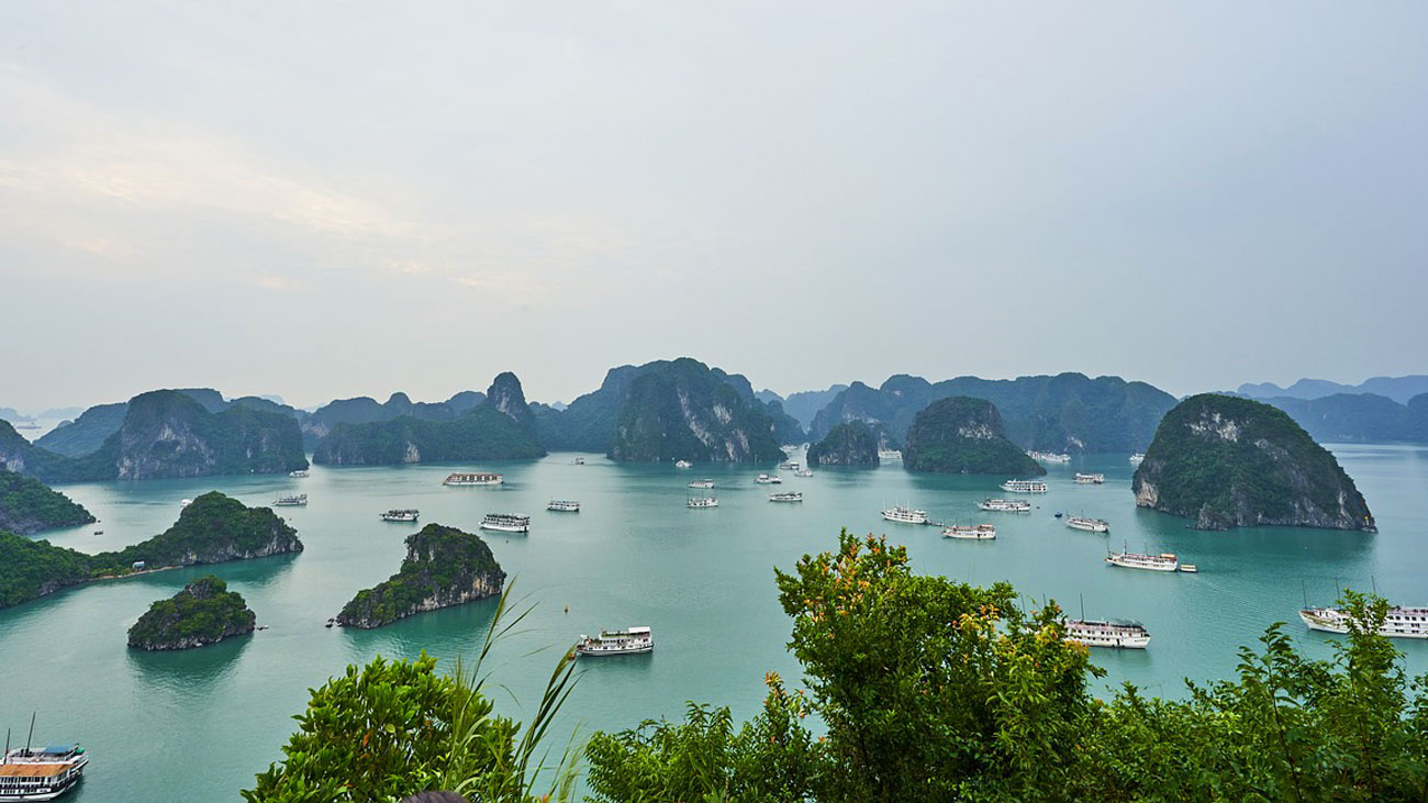 Halong Bucht: Boote, Kalksteininseln, bewölkter Himmel