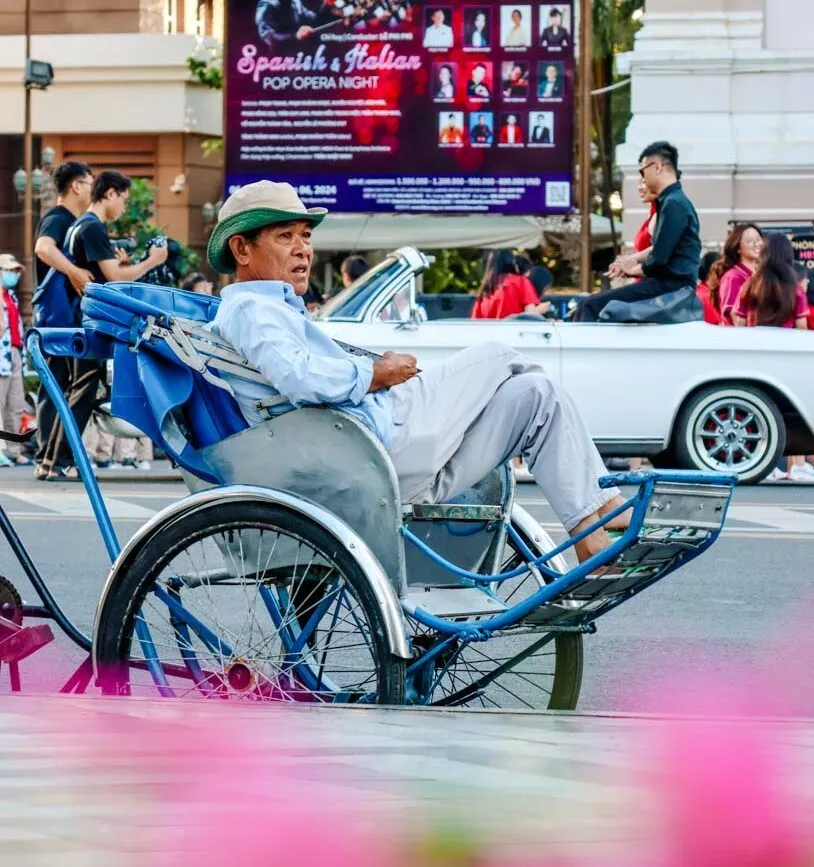 mann sitzt in rikscha auf belebter strasse in ho chi minh stadt Mann sitzt in Rikscha auf belebter Straße in Ho-Chi-Minh-Stadt