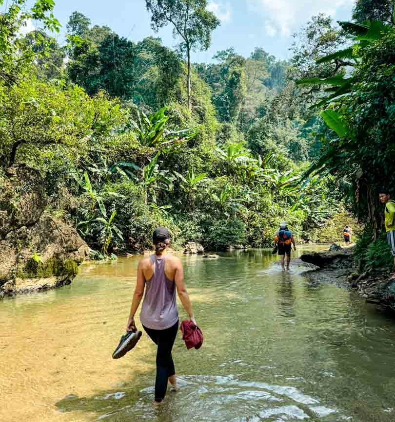 nina geht durch einen bach in phong nha
