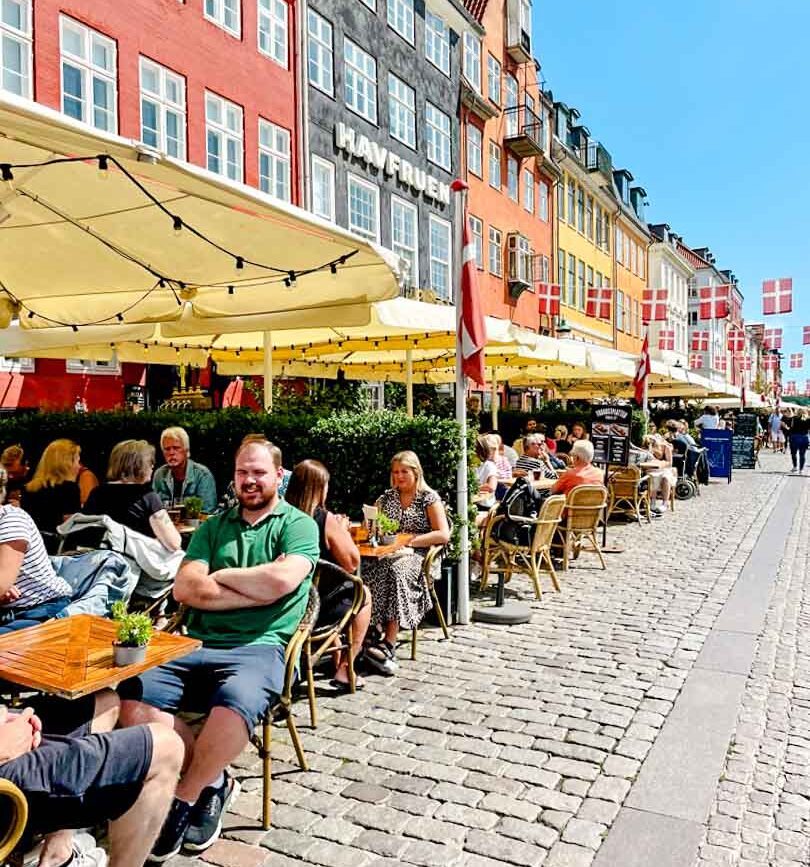 Nyhavn mit Restaurants und Tischen, Kopenhagen, Dänemark