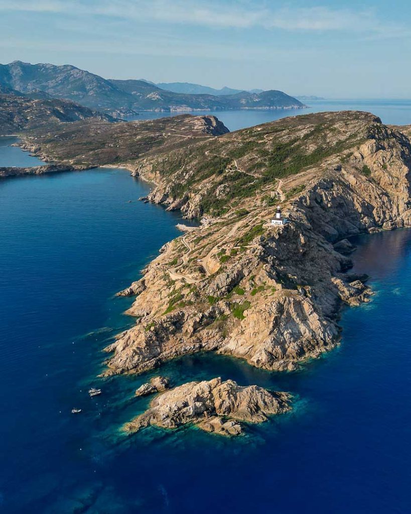 drohnenaufnahme von halbinsel la ravellata bei calvi mit leuchtturm Drohnenaufnahme von Halbinsel La Ravellata bei Calvi mit Leuchtturm